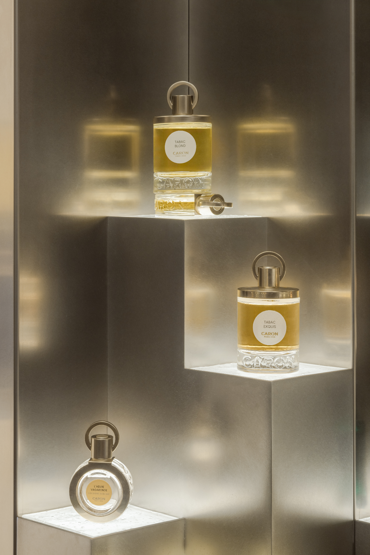 Parfums Caron, Rue Saint Honoré — Paris, France: Close-up of Caron perfume bottles on brushed metal display shelves